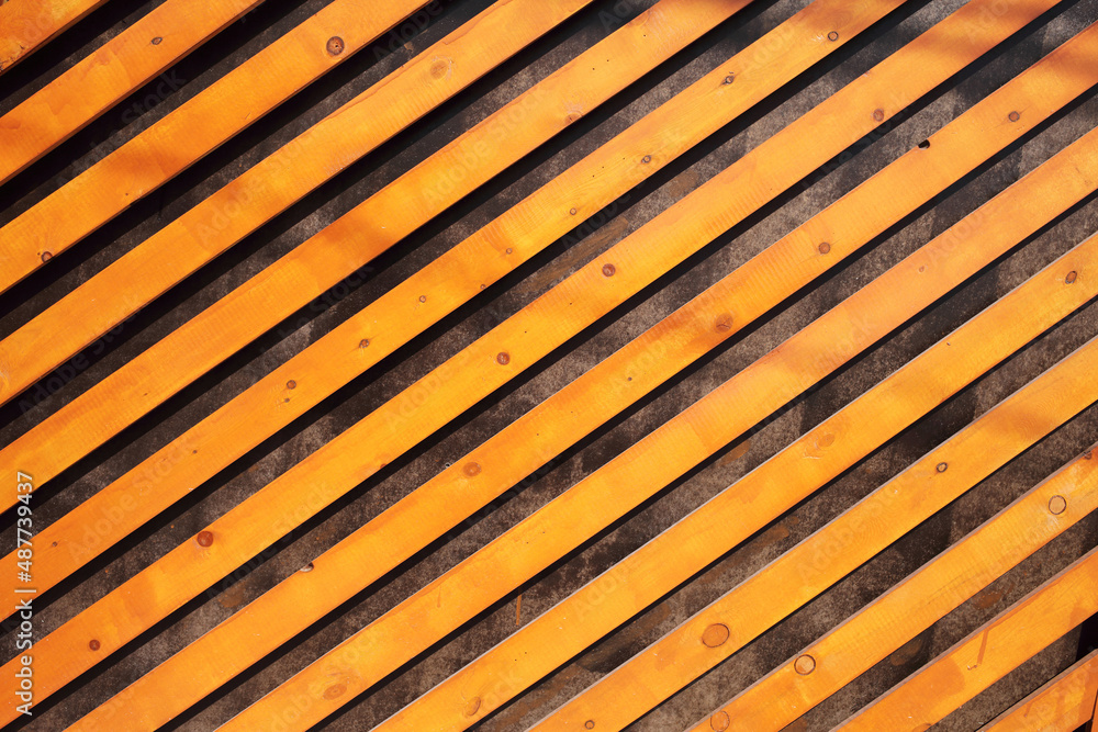 Decorative background of orange wooden slats arranged diagonally