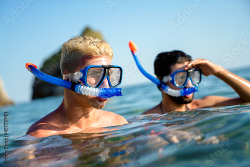 Happy friends men enjoying summer vacation and scuba diving