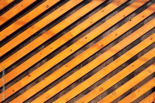 Decorative background of orange wooden slats arranged diagonally