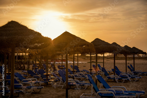 Fototapeta Naklejka Na Ścianę i Meble -  beach chairs and umbrellas at sunset