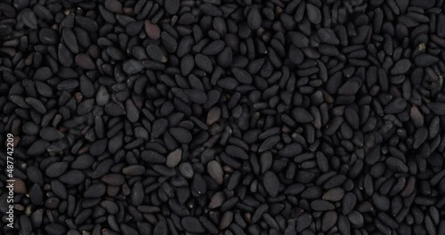 Top view of black sesame seeds rotating. Closeup. Macro.