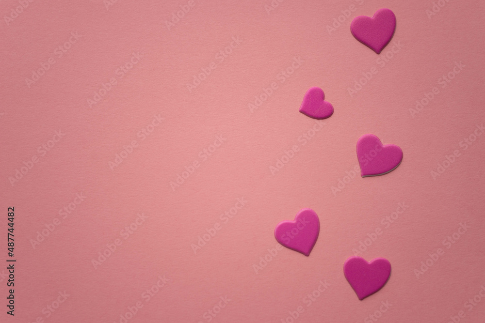 Lovely magenta pink hearts on pink paper table. Copy space.