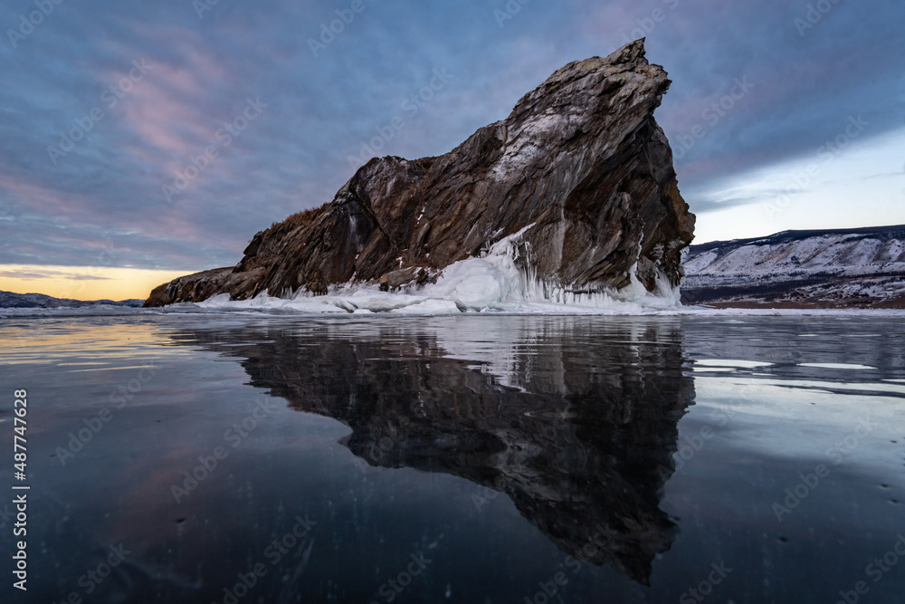 Reflection of a rocky island in the surface of the Baikal ice