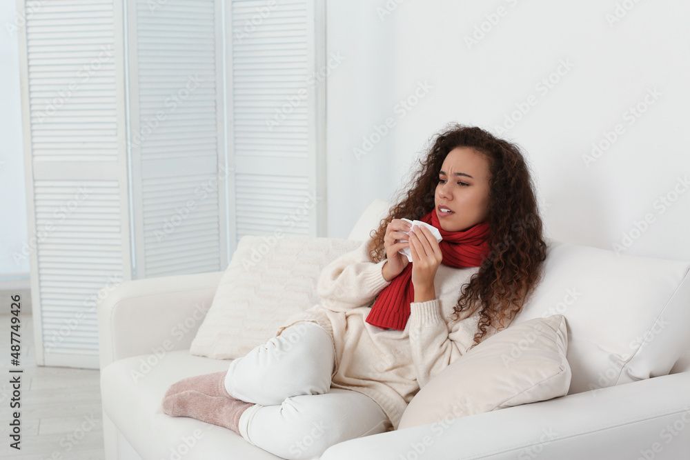Sick African American woman sneezing at home, space for text Sick African American woman sneezing at home, space for text