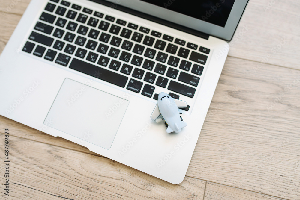 Blue toy plane on laptop. Travel concept Blue toy plane on laptop. Travel concept