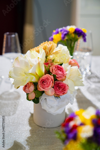 Beautiful bouquet of colorful flowers in a hat box on the dining table. 
