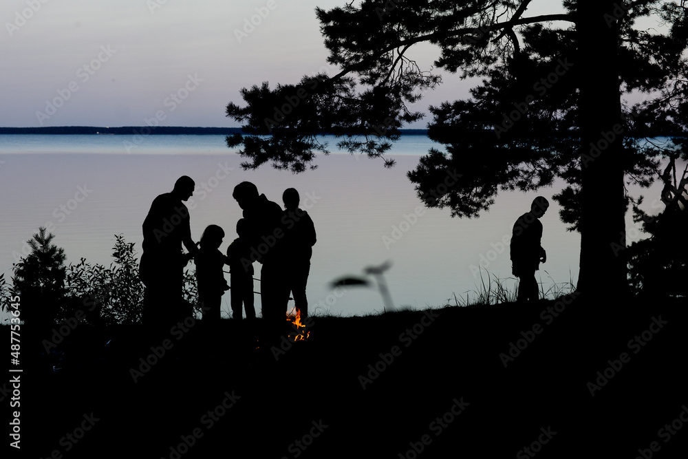 the family is relaxing in nature near the lake in the evening the family is relaxing in nature near the lake in the evening