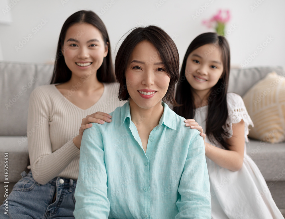 Mature Asian woman with her adult daughter and cute granddaughter posing at home, selective focus Mature Asian woman with her adult daughter and cute granddaughter posing at home, selective focus
