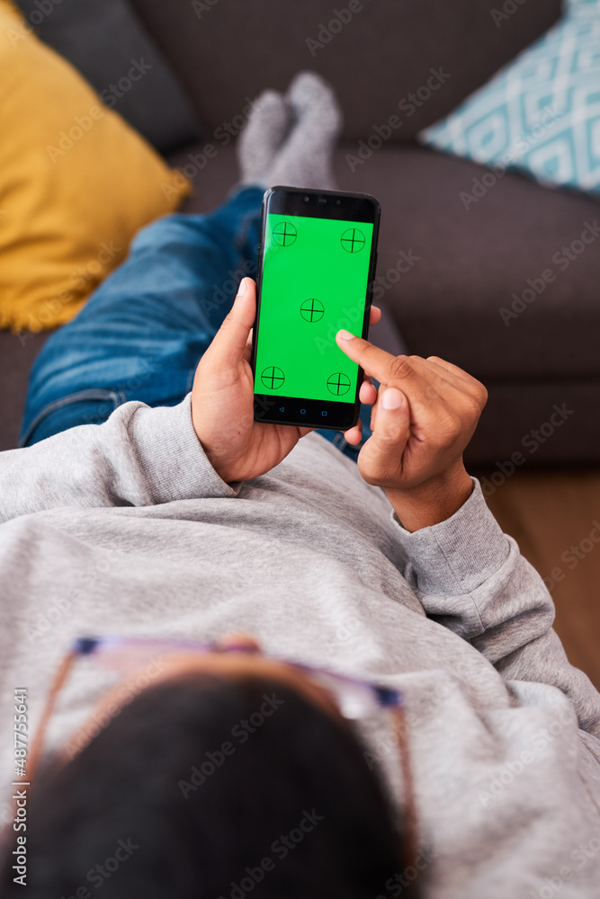 A man lies on the couch scrolling on his mobile phone A man lies on the couch scrolling on his mobile phone