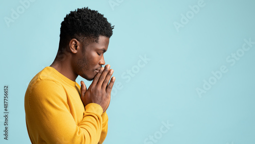 Side view of praying african american young man, copy space