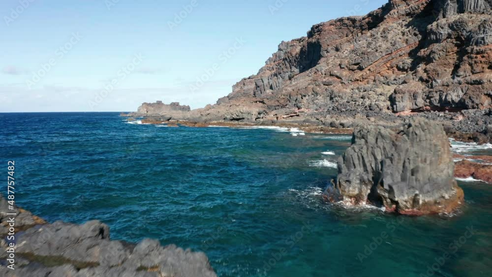 Aerial dolly over Atlantic ocean coast with volcanic relief in sunny Aerial dolly over Atlantic ocean coast with volcanic relief in sunny