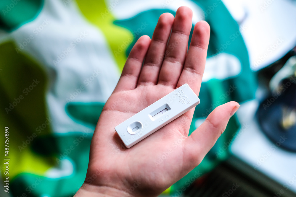 COVID-19 virus disease diagnostic, child holding coronavirus test cassette, rapid strep kit, quick antigen detection testing. Defocused COVID-19 virus disease diagnostic, child holding coronavirus test cassette, rapid strep kit, quick antigen detection testing. Defocused