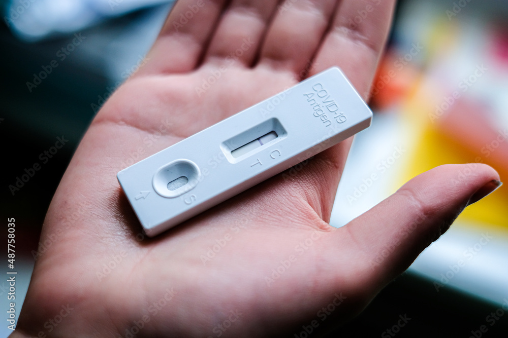COVID-19 virus disease diagnostic, child holding coronavirus test cassette, rapid strep kit, quick antigen detection testing. Defocused COVID-19 virus disease diagnostic, child holding coronavirus test cassette, rapid strep kit, quick antigen detection testing. Defocused