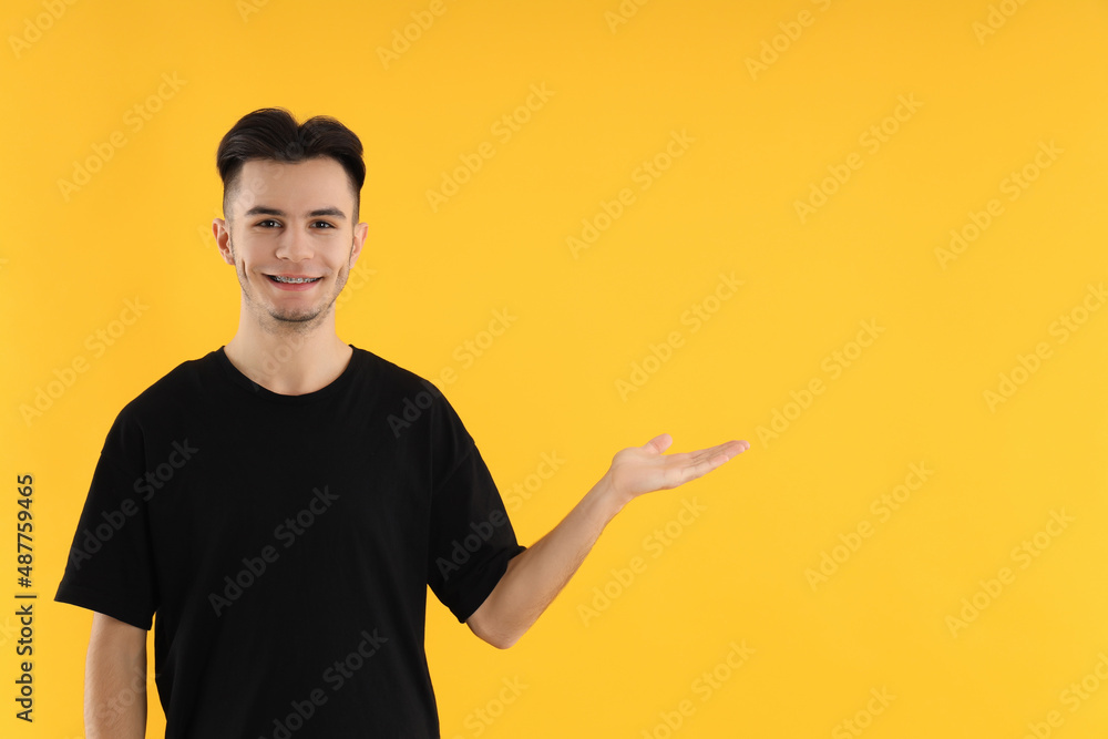Attractive young man in t-shirt on yellow background Attractive young man in t-shirt on yellow background