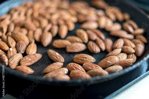 Almonds fried in a skillet.