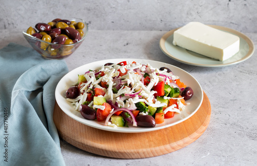 Bulgarian shopska salad with vegetables and brynza on wooden board photo