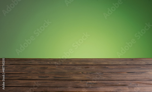 dark woodewn table on background bright green wall