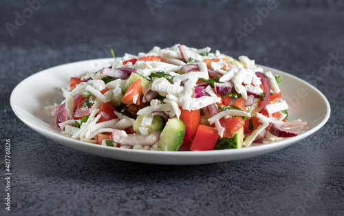 Bulgarian shopska salad with vegetables and brynza on dark background close up