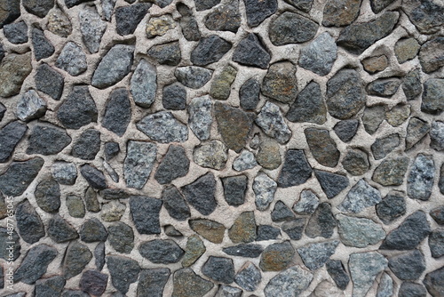 Rough surface of wall with dark gray gravel pebble dash