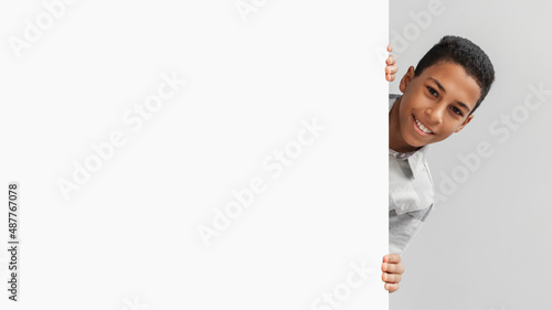 Photos African American Boy Posing With Empty Board On Gray Background