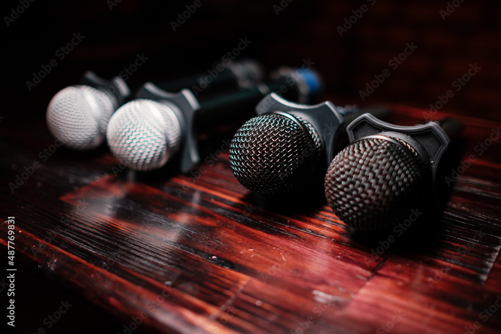 Obraz premium Several microphones lie on a wooden table. Karaoke is waiting for guests.