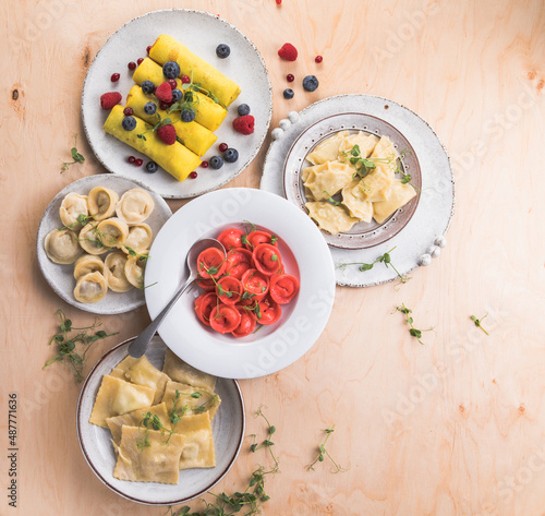 Assortment of Italian pasta dishes. Different types of tortellini  ravioli  dumpling  pierogi  crepes on wooden   background.