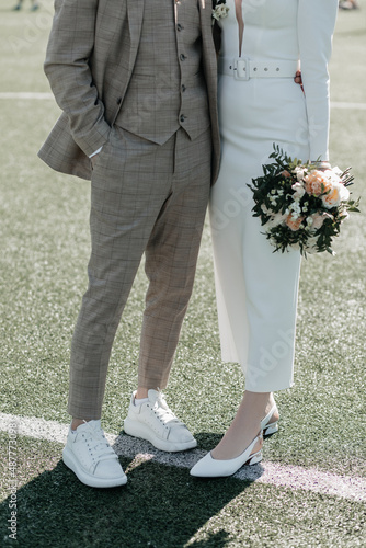 Young couple standing in an embrace after the wedding on the football field
