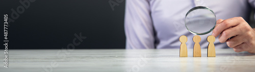 man holding magnifir with wooden pople photo