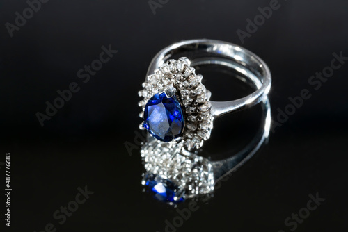 jewelry ring witht big blue sapphir on black coal background photo