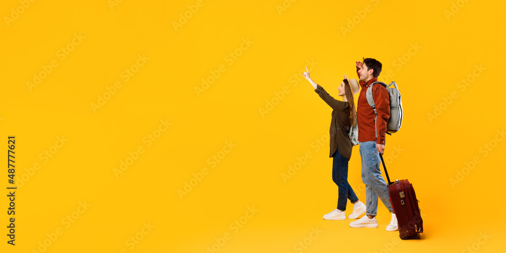 Naklejka premium Travelers Couple Pointing Finger Looking Aside At Copy Space, Studio