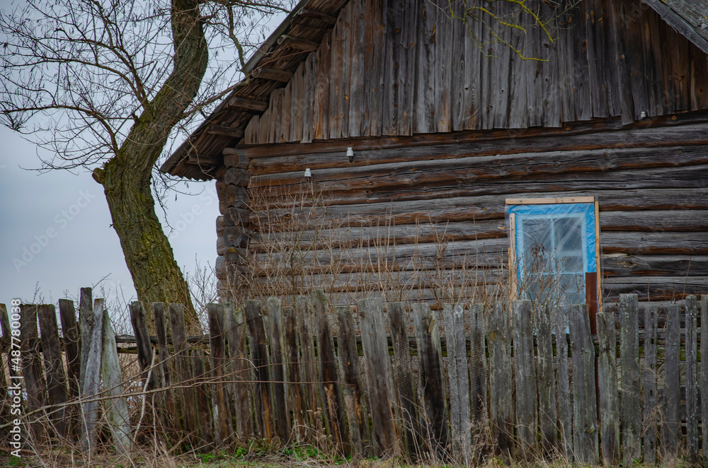 An old village house with a woodpile. Russian wooden village hut. Village hut view. Village hut in Russia. An old village house with a woodpile. Russian wooden village hut. Village hut view. Village hut in Russia.