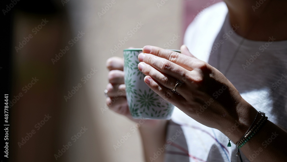 Person hands holding cup of tea or coffee