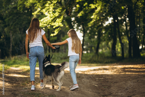 Two sisters with their dog in park