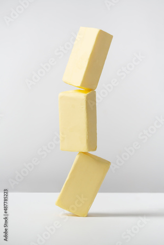 Creative photo with balancing butter on white background photo