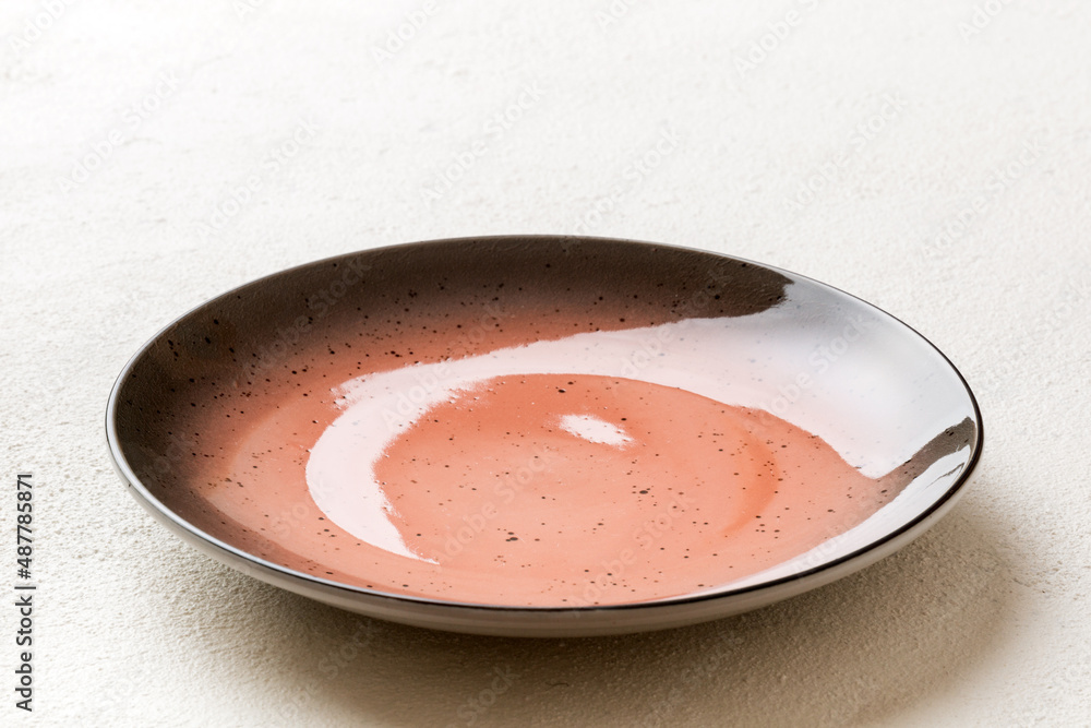 Perspective view of empty red plate on cement background. Empty space for your design Perspective view of empty red plate on cement background. Empty space for your design