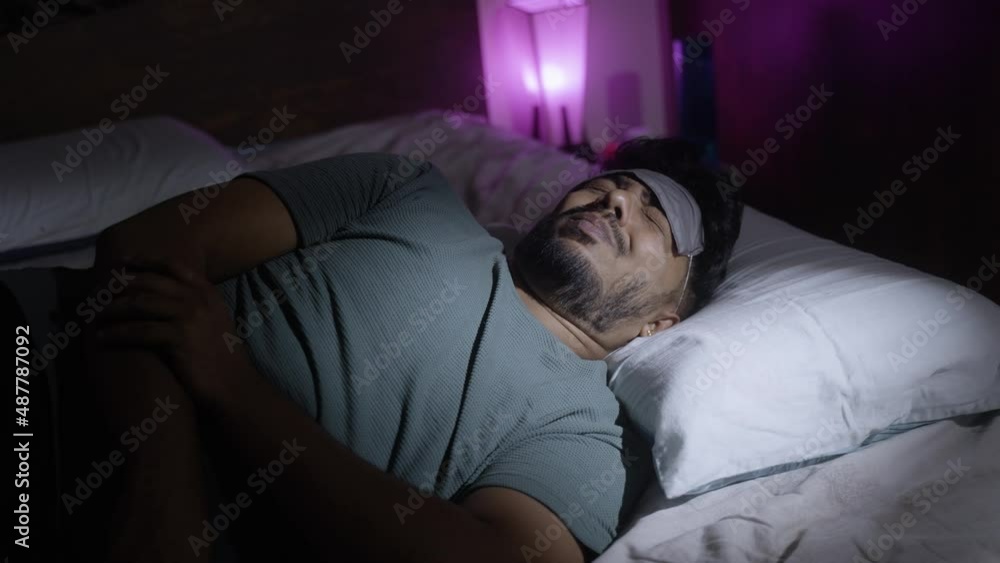 young man sleeping by wearing eye mask at bedroom - concept of night sleep, relaxation and bedtime. young man sleeping by wearing eye mask at bedroom - concept of night sleep, relaxation and bedtime.