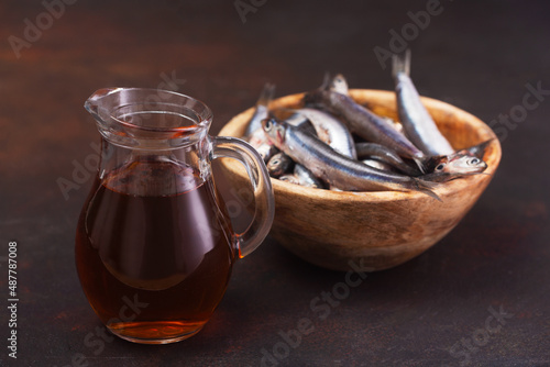 Garum fish sauce made from anchovies on the dark background photo