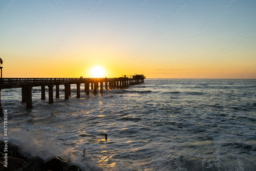 Old long wooden jetty at sunset