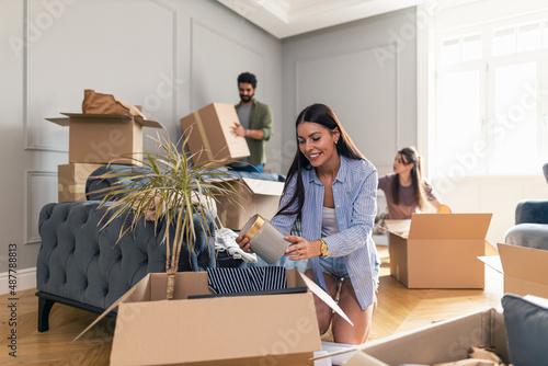 Fotografía Woman unpacking her things from cardboard box after moving in in her new apartment