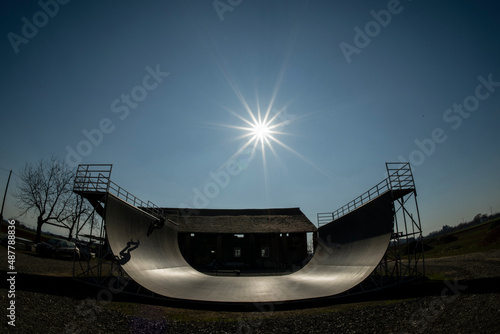 Young skateboarder in action, on a vert ramp with big shadow