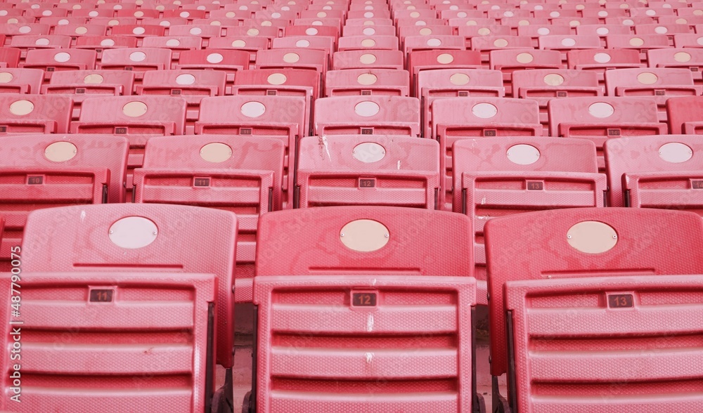 Obraz premium Empty red foldable seats in the stands at the football stadium