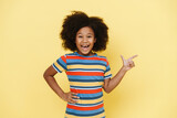 Black preteen girl with curly hair laughing and pointing finger aside