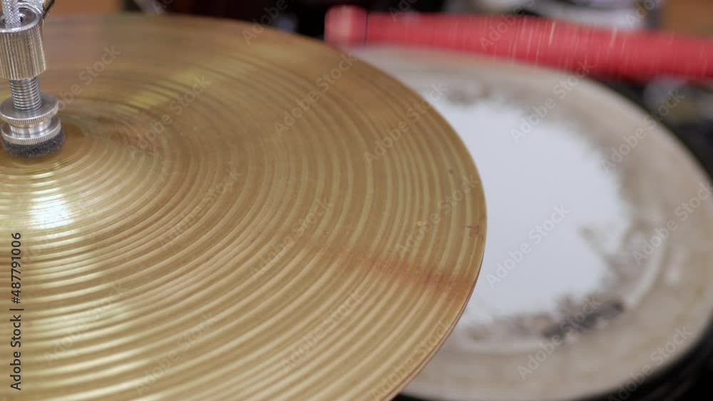 red drumstick hitting the hi-hat cymbal red drumstick hitting the hi-hat cymbal