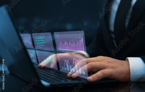 Businessman analysing economic growth graph financial data on digital screen. HUD charts diagram,statistics and data analytics.