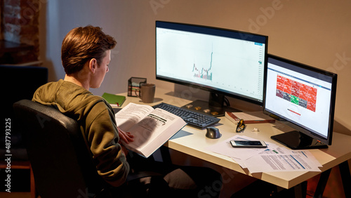 Male trader reading educational book at desk