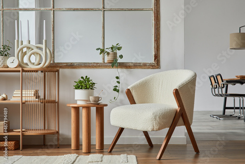 Stylish compositon of modern living room interior with frotte armchair, wooden commode, side table and elegant home accessories. Home staging. Template. Copy space..Dining room in the background.. photo