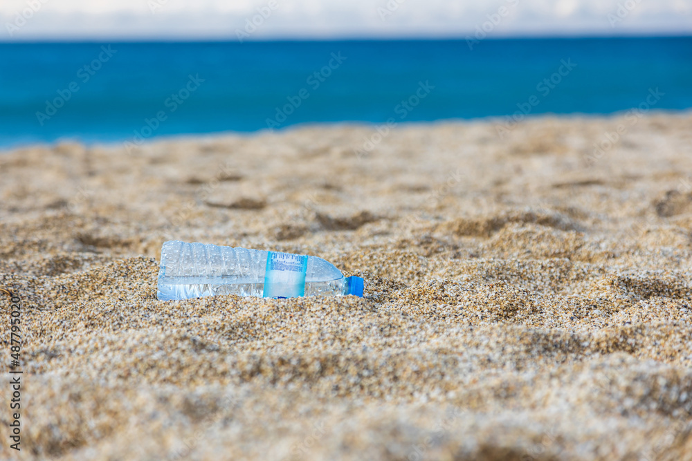 Garbage pollution of the planet. Empty plastic bottle on the beach sand. Consequences of human life Garbage pollution of the planet. Empty plastic bottle on the beach sand. Consequences of human life