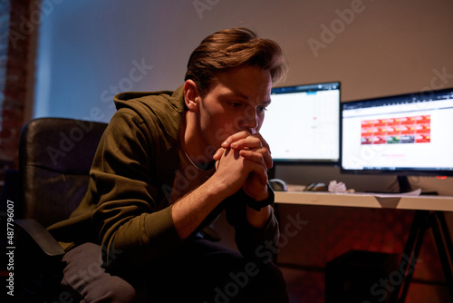Sad male trader near desk with stock market data photo