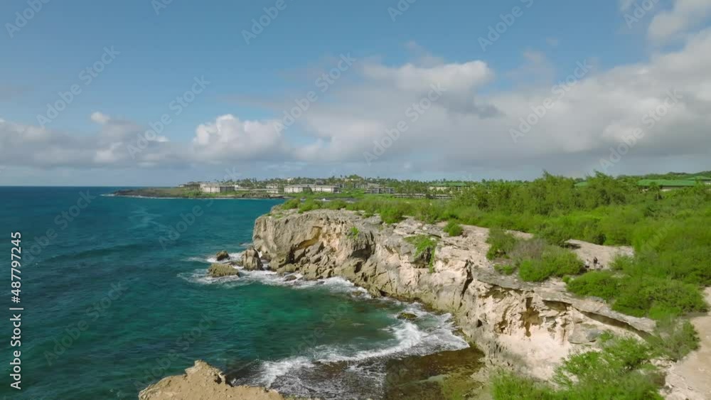 Slow aerial shot moving forward low over the cliffs at Shipwreck beach, Hawaii. Some buildings and beautiful horizon in the background. Slow aerial shot moving forward low over the cliffs at Shipwreck beach, Hawaii. Some buildings and beautiful horizon in the background.