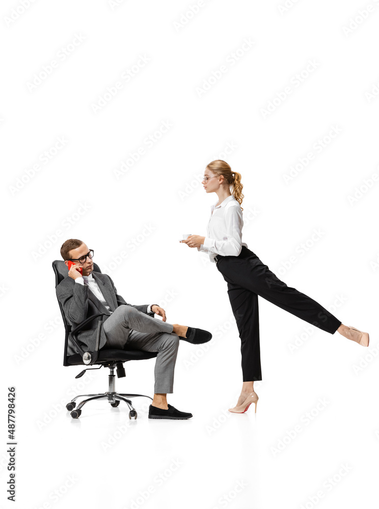 Co-workers. Two stylish office workers in business suits in action isolated on white background. Art, beauty, fashion and business concept Co-workers. Two stylish office workers in business suits in action isolated on white background. Art, beauty, fashion and business concept